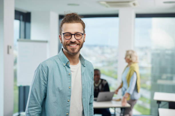 istock A happy, successful young professor is standing in a classroom and smiling at the camera. 1408386244