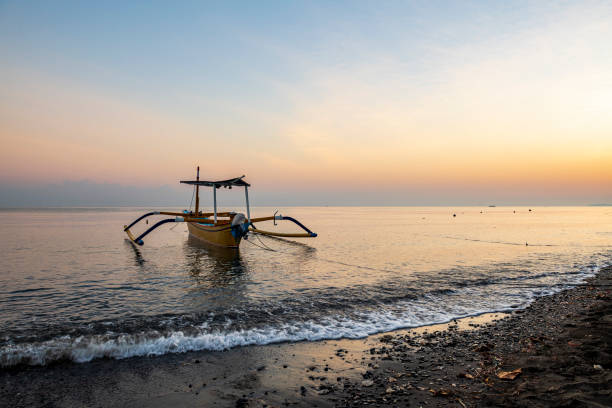 The traditional balinese boat Jukung at sunrise at Lovina beach in Bali.