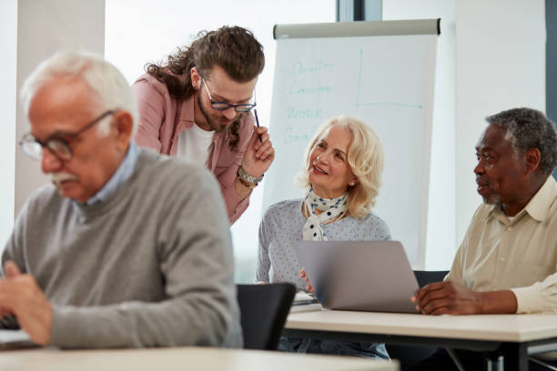 istock A young teacher teaches a small group of multicultural senior students how to use technologies. 1408386707