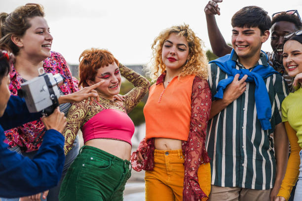 istock Young diverse people having fun with old vintage video camera outdoor 1408388359
