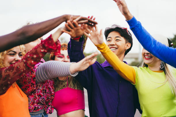 istock Young diverse people celebrating together stacking hands outdoor 1408388363