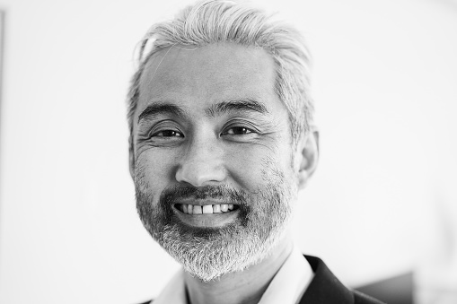 Business senior asian man smiling at camera - Focus on face - Black and white editing