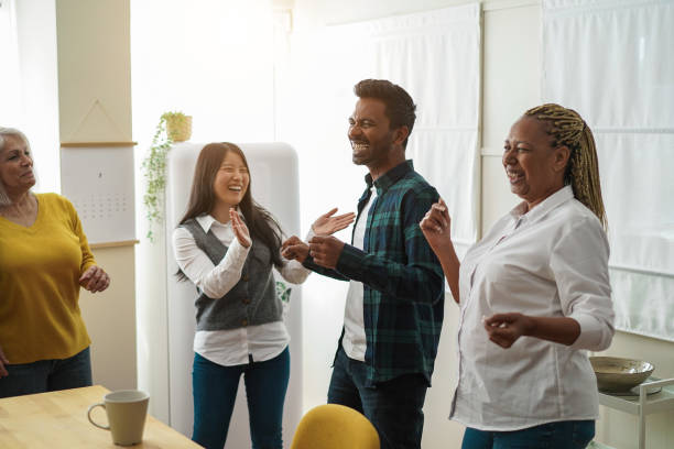 istock Multiracial happy friends having fun dancing together in the kitchen 1408390006