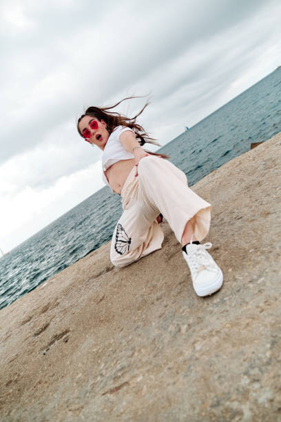 Young urban style dancer doing a dance pose outdoors against the sea.