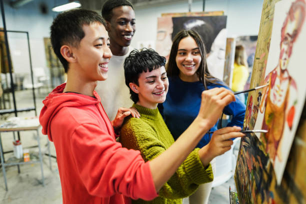 des étudiants multiraciaux peignent dans une salle d’art à l’université - artist child artists canvas indoors photos et images de collection