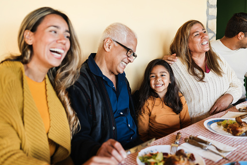 Happy latin family having fun eating together home - Focus on grandmother face