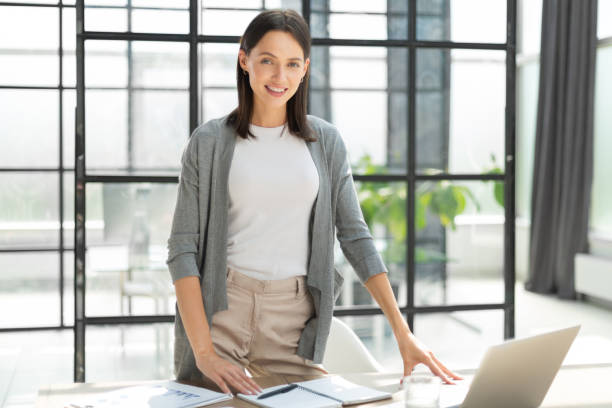 istock Attractive business woman smiling while standing in the office 1408393257