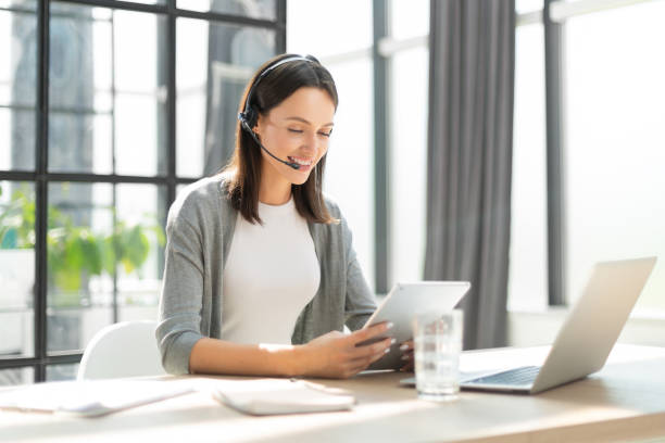 istock Attractive smiling woman working on a tablet in modern office 1408393821