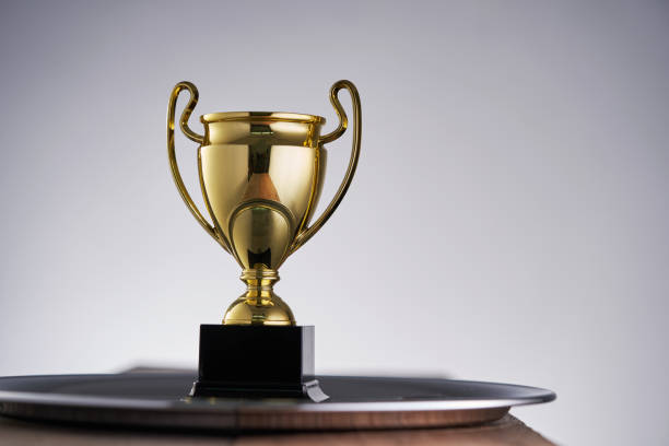 istock gold colored trophy against gray background 1408395319