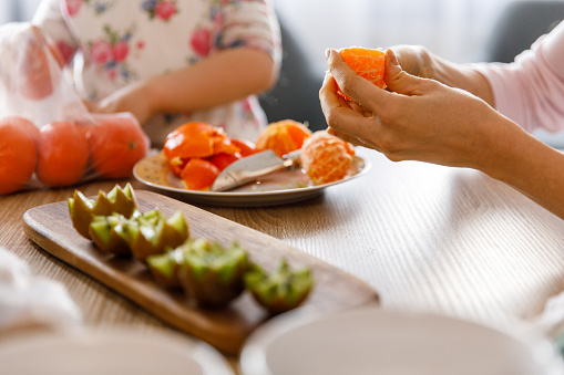 Woman peeling tangerine.