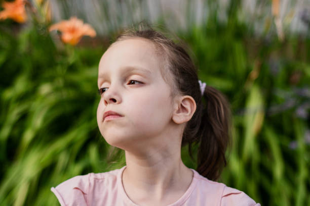 istock Child enjoying in sunlight against flower background 1408399041