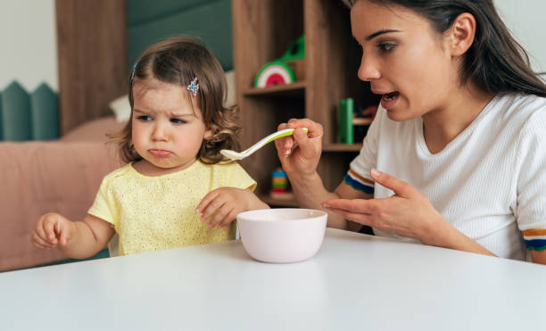 istock Mother feeding her girl 1408402090
