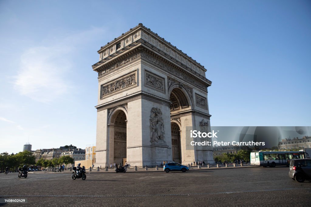 Traffic moving around the Arc de Triomphe The Arc de Triomphe, late afternoon in springtime Driving Stock Photo