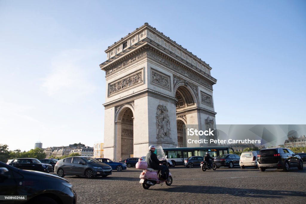 Traffic moving around the Arc de Triomphe The Arc de Triomphe, late afternoon in springtime Arc de Triomphe - Paris Stock Photo