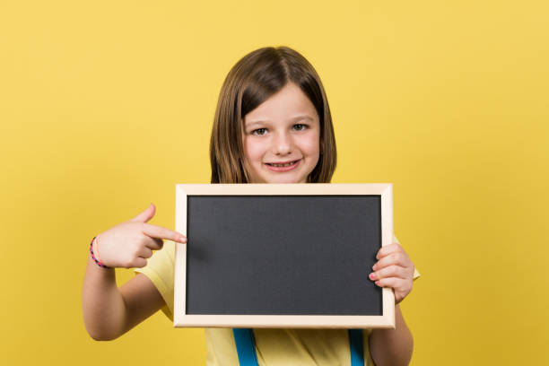 istock Little girl pointing at blackboard 1408404872