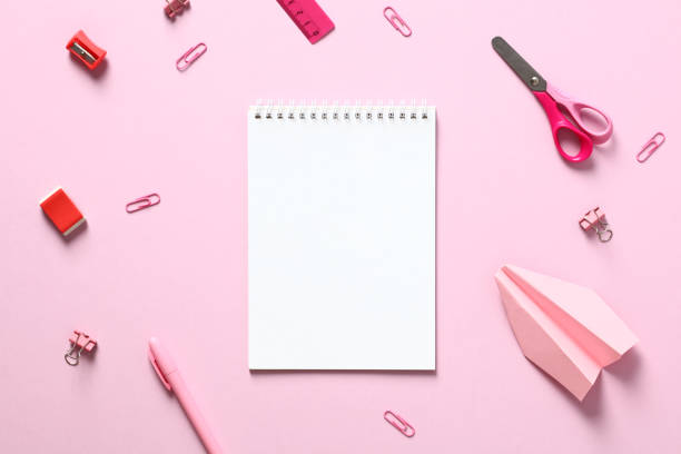 istock Blank paper notepad with school supplies on pink table. Flat lay, top view, copy space. 1408405469