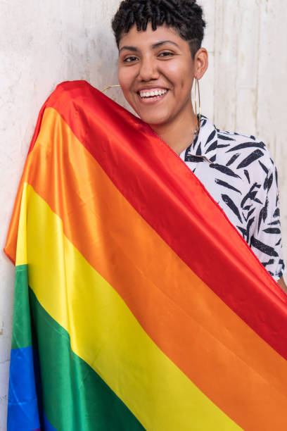 istock Ethnic woman leaning back with rainbow flag on pavement 1408405495