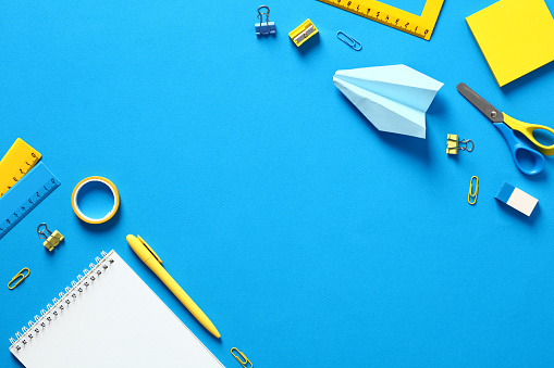 Back to school concept. School supplies on blue background. Flat lay, top view, copy space.