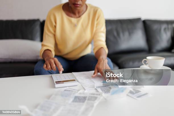 Close Up Of A Mid Adult Woman Checking Her Energy Bills At Home Sitting In Her Living Room She Has A Worried Expression Stock Photo - Download Image Now