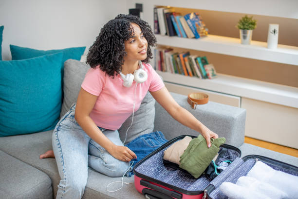 istock Young woman packing suitcase 1408407344