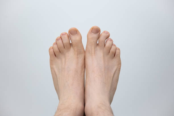 Caucasian male bare feet isolated against white background, Close up front shot, unrecognizable person stock photo