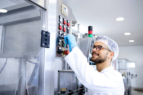 istock Pharmaceutical worker or technologist operating production machine in medicine factory. 1408410350
