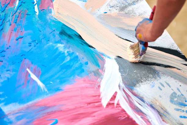 Drip painting expression art on canvas with blue, pink and beige colors, artist art performance stock photo
