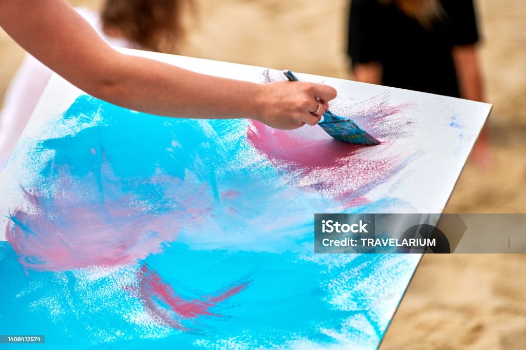 Amateur painter drawing picture on white canvas at outdoor art exercise, painting performance Amateur painter drawing picture on white canvas at outdoor art workshop. Woman artist hands with paintbrush painting new picture, outdoor art exercise, painting performance Acrylic Painting Stock Photo