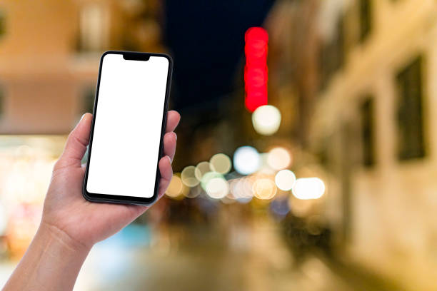 istock Hand holding blank screen smartphone with defocused night city lights background 1408412930