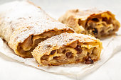 homemade apfelstrudel, Apple strudel with raisins and mint on light background. view from above, Food recipe background, austrian germany food