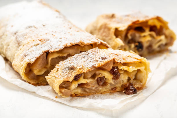 homemade apfelstrudel, Apple strudel with raisins and mint on light background. view from above, Food recipe background, austrian germany food homemade apfelstrudel, Apple strudel with raisins and mint on light background. view from above, Food recipe background, austrian germany food. strudel stock pictures, royalty-free photos & images