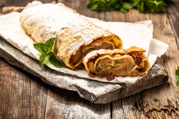 Homemade traditional Apple strudel powdered sugar on a wooden background. Christmas homemade pastry stock photo