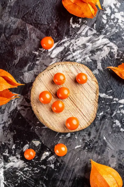 Physalis fruit Physalis Peruviana with husk on wooden background, vertical image, place for text.