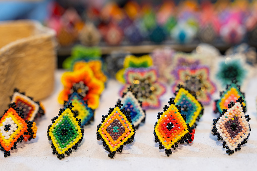 Colorful handmade huichol rings at night market in Guadalajara, Mexico. Traditional Mexican handcraft souvenirs