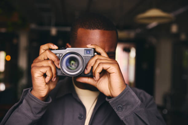 istock Photographer Taking A Picture With Camera Looking Through Lens 1408417694