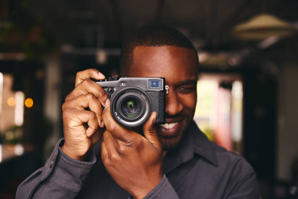istock Photographer Taking A Picture With Camera Looking Through Lens 1408417701