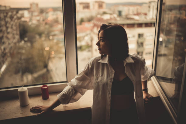 istock Young Woman Leaning On The Window Sill 1408417970