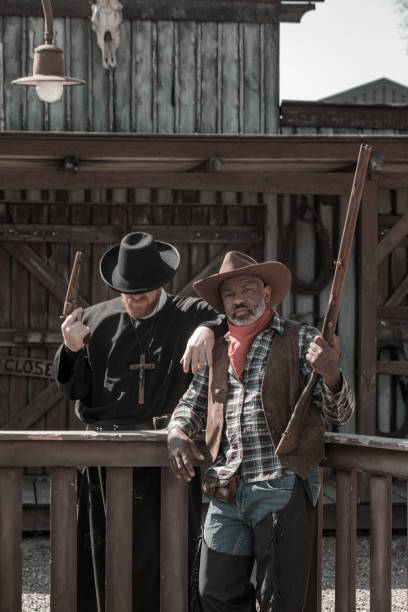 istock Handsome Black Cowboy with a priest in an authentic wild west setting 1408418496