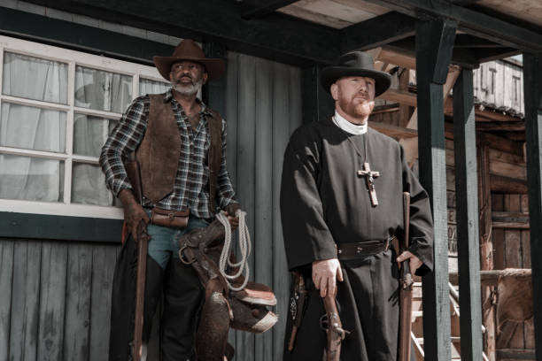 istock Handsome Black Cowboy with a priest in an authentic wild west setting 1408418667