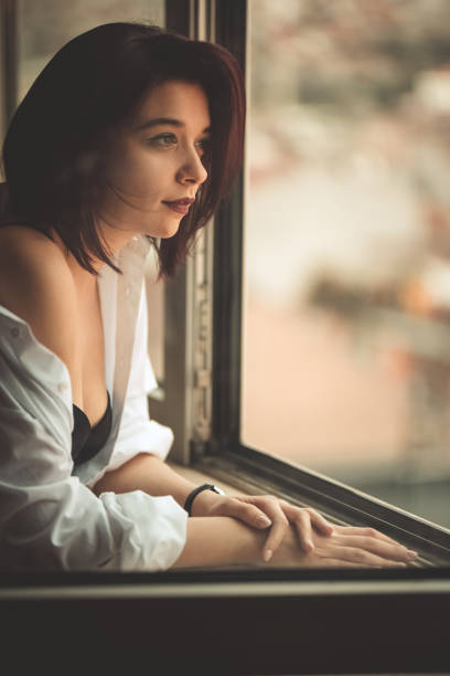istock Young Woman Looking Out The Window 1408418802