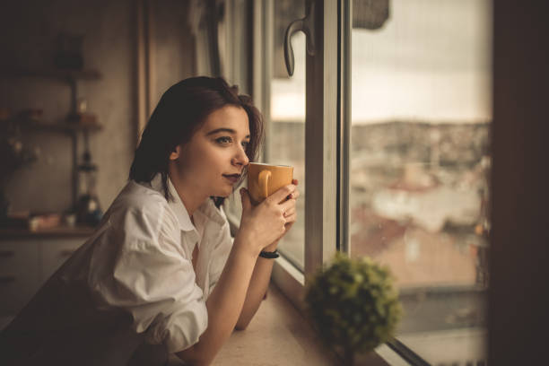 istock Young Woman Looking Out The Window 1408420032