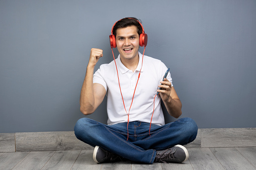 cheerful young man enjoying listening to his favourite song