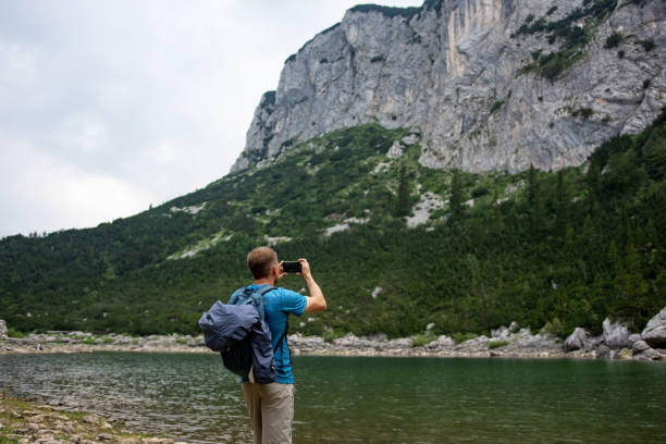 istock Young man taking photographs in a mountains 1408424256