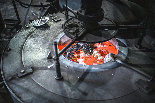 Crucible furnace melting metals at high temperatures in an industrial factory. Aluminium casting process.