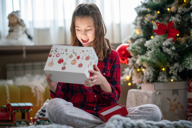 istock Girl opening Christmas present at home 1408426841