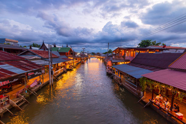 vue sur les villes du marché flottant d’amphawa et les touristes font du shopping, mangent et prennent des photos dans la région. il y a de nombreux restaurants dans la région. est l’un des - damnoen saduak floating market photos et images de collection