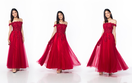 Full length body of Asian beautiful woman wear red evening sequin gown, Young female stand express feeling happy smile over white background isolated