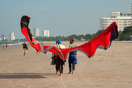 hua hin thailand may 4 2006 -two  unknown man carrying his kite sail on the beach in hua hin in thailand