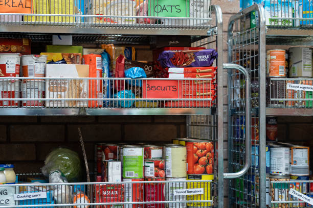 Nonperishable Food at a Food Bank Close up of a shelving unit containing nonperishable food in storage at a food bank in the North East of England. food bank stock pictures, royalty-free photos & images