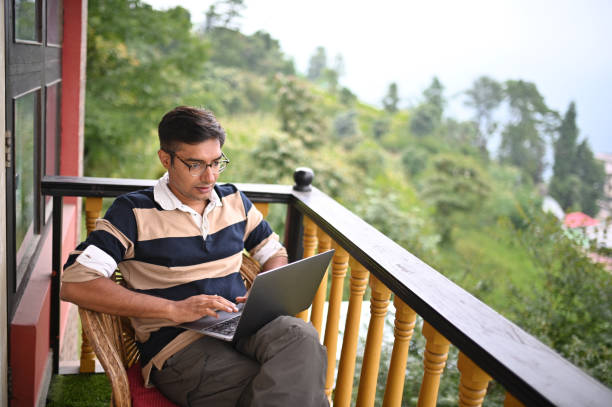 istock Man working on laptop sitting in the Balcony at a scenic remote location 1408433251